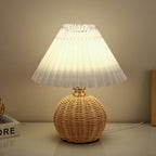 Lampada da tavolo LED base in rattan intrecciato paralume plissettato