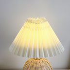 Lampada da tavolo LED base in rattan intrecciato paralume plissettato