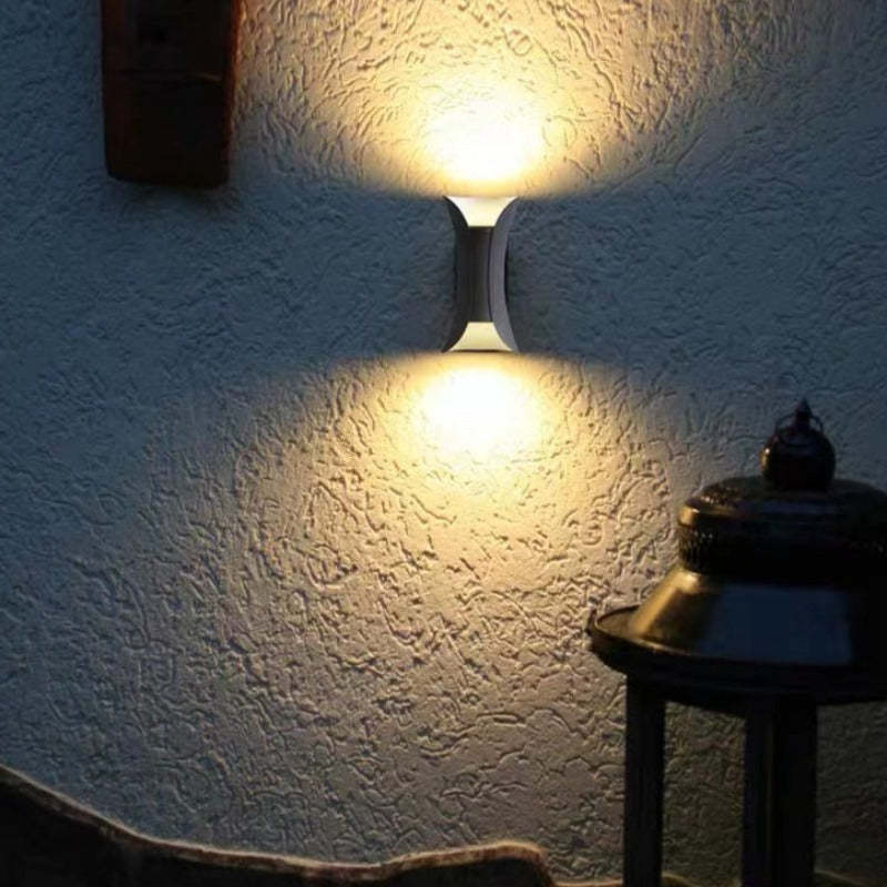 Modern outdoor LED wall light with curved design directing light up and down