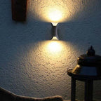 Modern outdoor LED wall light with curved design directing light up and down