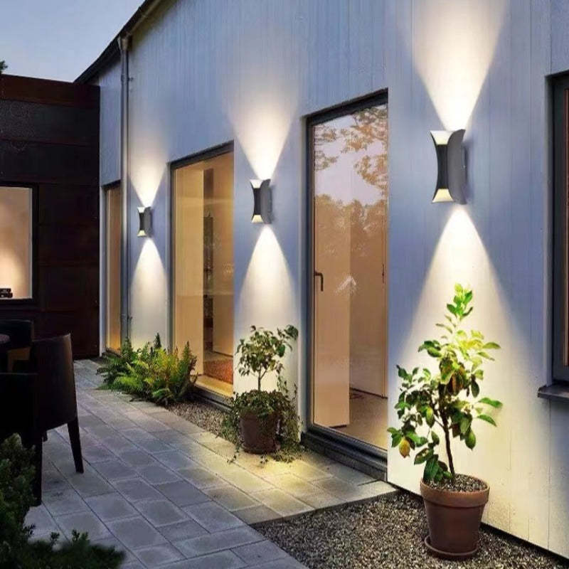 Modern outdoor LED wall light with curved design directing light up and down